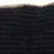 Nahaufnahme eines schwarzen, strukturierten Stoffes mit goldener Kordel am Rand. Materialdetails für Produktbeschreibung.