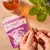Hands breaking a calming treat in half with Forthglade calming soft bites packaging visible in the background.