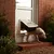 A dog using a pet door flap installed in a white exterior door, demonstrating how the product allows pets to move between indoors and outdoors.