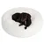 Zwarte hond ligt in een rond, wit, pluizig bed.