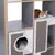 Regalsystem mit integrierter Katzenhöhle und Kratzflächen aus Sisal. Katze liegt auf gepolsterter Liegefläche oben.