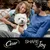 Cesar, SHARE THE Joy. White dog sitting between two people on a sofa. Visible Cesar brand and campaign slogan at the bottom.