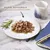 Assiette de filets en sauce avec texte « FILETS SAVOUREUX » au-dessus, branche de romarin à gauche, carnet bleu et stylo doré à droite.