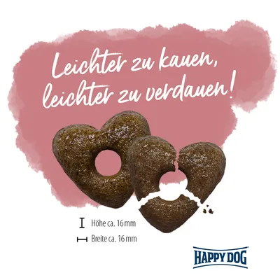 Texte en allemand : Leichter zu kauen, leichter zu verdauen! Deux croquettes en forme de cœur, dimensions env. 16 mm x 16 mm. Marque Happy Dog visible.