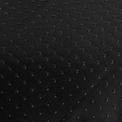 Primo piano di un materiale nero idrorepellente con piccoli punti per una superficie antiscivolo.