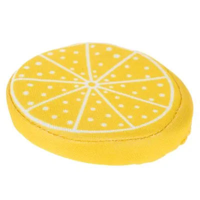 Rond hondenspeelgoed van stof met citroenprint, geel met witte segmenten en stippen zichtbaar op de bovenkant.