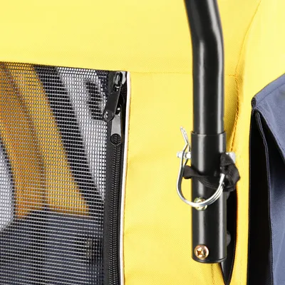Close-up of a yellow transport trolley with mesh window, zip and black metal frame with safety hooks.