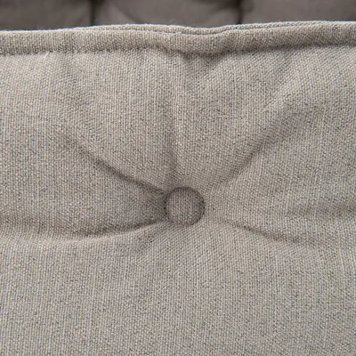 Nahaufnahme eines grauen, strukturierten Stoffes mit Knopfdetail. Polsterung sichtbar.