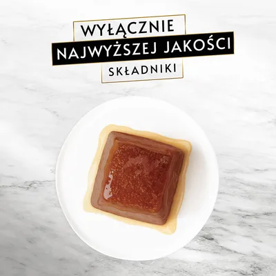 Wyłącznie najwyższej jakości składniki – tekst na górze. Na talerzu kwadratowa porcja mokrej karmy w galarecie.