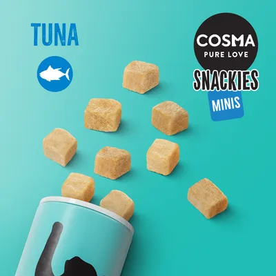 Cosma Pure Love Snackies Minis, cubetti di snack fuoriusciti da un contenitore azzurro. Testo visibile: TUNA con icona pesce, COSMA PURE LOVE SNACKIES MINIS.