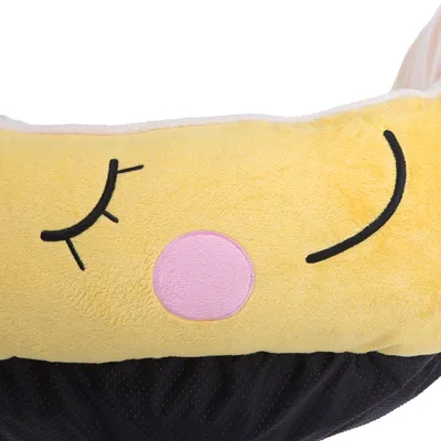 Detalle de cama para mascotas con tela amarilla y negra, diseño bordado de cara sonriente con ojos cerrados y círculo rosa en el centro. Material visible: felpa.