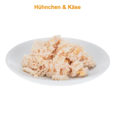 Portie natvoer op wit bord met zichtbare stukjes kip en kaas. Tekst bovenaan in het Duits: Huhnchen & Käse.