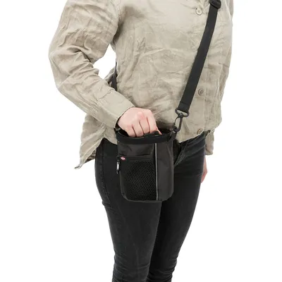 Person carrying a black treat bag with shoulder strap and mesh pocket, suitable for on the go.