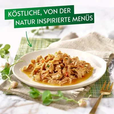 Köstliche, von der Natur inspirierte Menüs. Teller mit zarten Fleischstücken in Sauce, dekoriert mit frischen Kräutern.