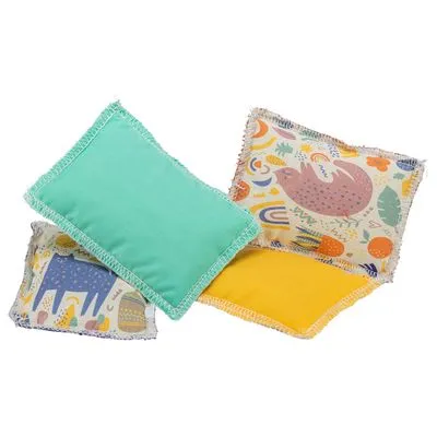 Vier stoffen kussentjes, twee met effen kleuren (groen, geel) en twee met dieren- en regenboogmotieven. Materialen: stof. Geen merknaam of tekst zichtbaar.