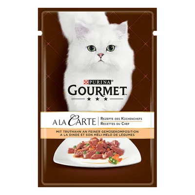Purina Gourmet A la Carte, przepisy szefa kuchni, z indykiem i delikatną kompozycją warzyw. Przedstawienie białego kota i podanego dania.