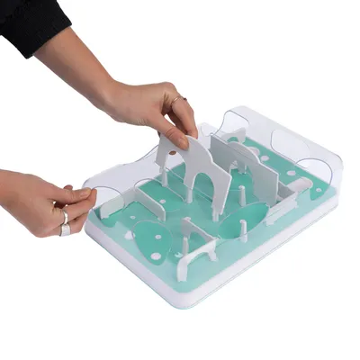 Hand-assembled white plastic parts on a green game board with transparent walls. Product shows interactive accessory for pets.