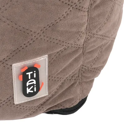 Tiaki-Logo auf braunem Stoff mit gestepptem Muster.