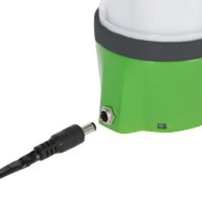 Zbliżenie na zieloną podstawę urządzenia z widocznym gniazdem zasilania i wtyczką kabla do podłączenia.