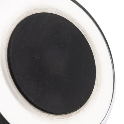 Detailní záběr na černou kulatou plochu s bílým okrajem, pravděpodobně část produktu nebo příslušenství.