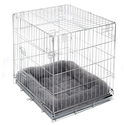 Metallkäfig mit Gitterwänden und grauem, gepolstertem Bett im Inneren. Käfig mit Tür und Verriegelungssystem sichtbar.