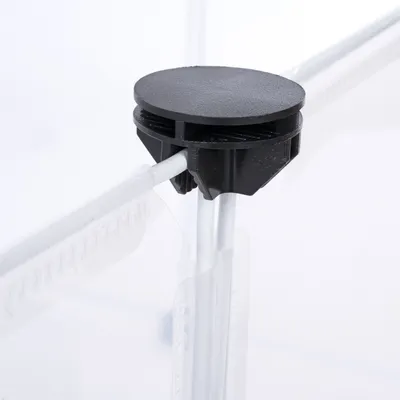 Connecteur en plastique noir fixé à deux barres métalliques et panneaux transparents, détail d’assemblage pour structure modulaire ou parc pour animaux.
