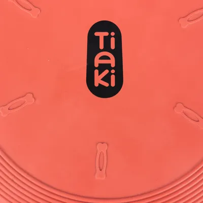 Tiaki-logo på et orange produkt med knogleformede detaljer.