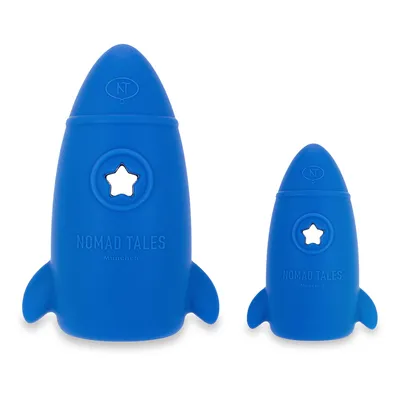 Kaksi sinistä raketinmuotoista lelua tähtiaukolla, Nomad Tales München -logo näkyvissä.