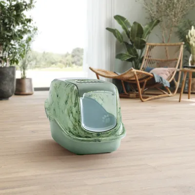 Uzavřená kočičí toaleta v zeleném mramorovém designu s průhlednými dvířky a motivem tlapky, umístěná na dřevěné podlaze v moderním interiéru.