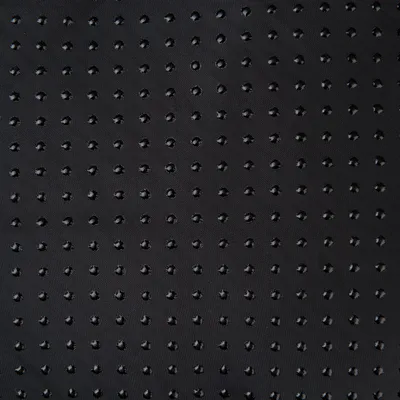 Close-up van een zwart, antislip materiaal met kleine, gelijkmatig verdeelde nopjes.