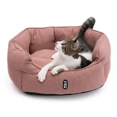 Tiaki Katzenbett in Rosa mit einer Katze, die darin liegt. Weiches, gepolstertes Design für Haustiere sichtbar.
