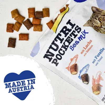 Nutri Pockets Sea Mix kattgodis, synlig text: mit Lachs with Salmon, mit Forelle with Trout. Hjärtformad symbol med texten MADE IN AUSTRIA. Flera godisbitar visas.