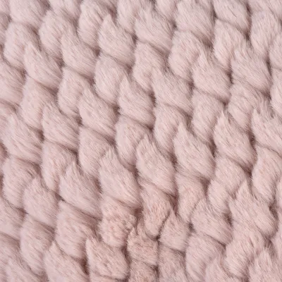 Gros plan sur une maille épaisse en tissu doux de couleur rose pâle, aspect tricoté. Matériau visible : textile.