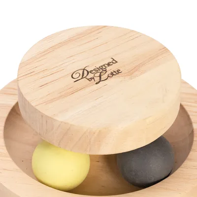 Holzspielzeug mit gelber und grauer Kugel, graviert mit 'Designed by Lotte'.