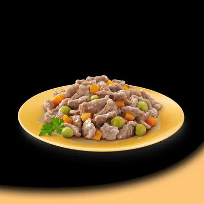 Chunks of meat with peas and diced carrots served on a yellow plate, shown as a serving suggestion for pet food.
