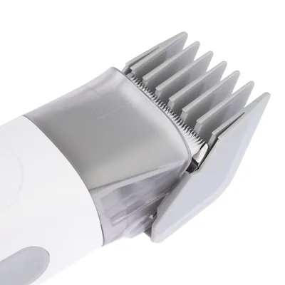Close-up of electric pet hair clipper with grey plastic comb attachment and visible metal blades. No brand or text shown.