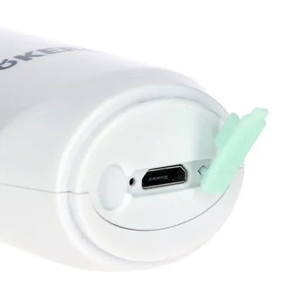Nahaufnahme eines weissen Geräts mit Micro-USB-Anschluss und grünem Schutzdeckel.