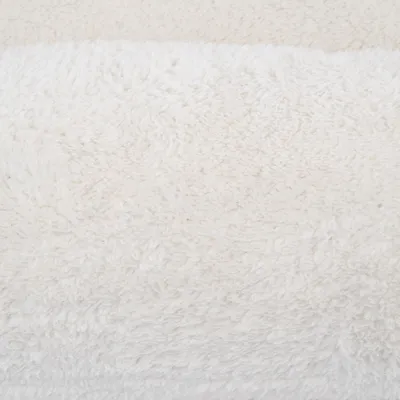 Close-up of white, fluffy fabric with soft texture, suitable for pet products such as beds or blankets.