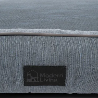 Modern Living. Детальный вид серой тканевой обивки с логотипной этикеткой.