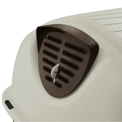 Nærbillede af et brunt ventilationsgitter med drejelås på en hvid transportkasse.