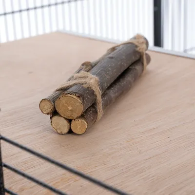 Bastoncini di legno naturale legati con spago di juta su una base di legno. Adatto per gabbie o recinti.