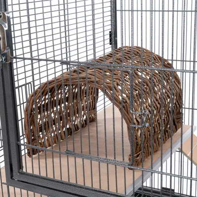 Punottu tunneli luonnonmateriaaleista metallihäkissä puisella alustalla.