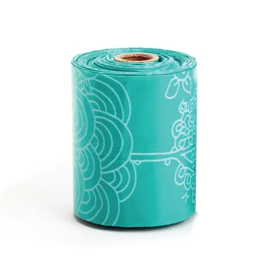 Rol met turquoise hondenpoepzakjes, decoratief bloemenpatroon in wit zichtbaar.