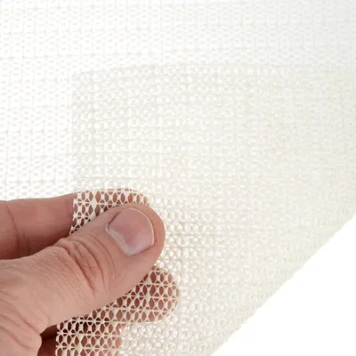 Weisse rutschfeste Matte mit feiner Netzstruktur, von Hand gehalten. Geeignet für Stabilisierung von Gegenständen auf glatten Oberflächen.