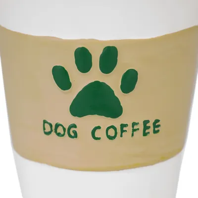Beżowy kubek z zielonym odciskiem łapy i napisem 'Dog Coffee'.