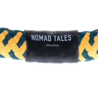 Nomad Tales München. Flettet legetøj med gule og grønne stofstrimler.