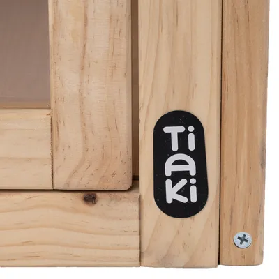 Tiaki logo na drvenom proizvodu s vidljivim vijkom i prirodnom drvenom teksturom.