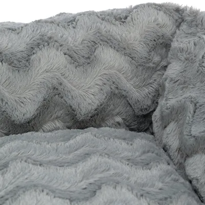 Nahaufnahme von grauem, weichem Plüschstoff mit Zickzack-Muster. Materialstruktur sichtbar.