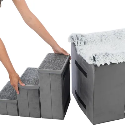 Graue, dreistufige Treppe mit Teppichoberfläche wird von einer Person an eine gepolsterte Box mit Plüschbezug und Klettverschlüssen angebracht.