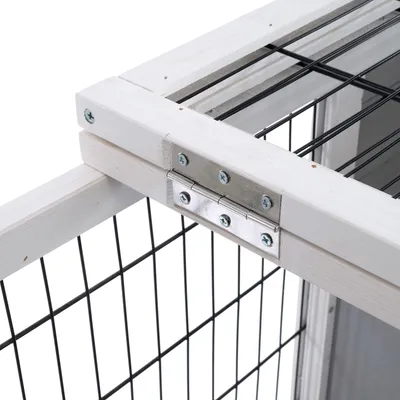Detailansicht eines Geheges mit Holzrahmen, Metall-Scharnieren und schwarzem Gitterdesign.